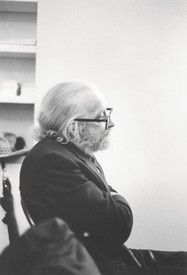 black and white photograph of an old man sitting in a chair