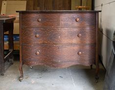 an old chest of drawers in a garage