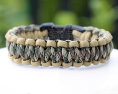 a close up of a bracelet on top of a white surface with trees in the background