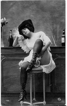 an old photo of a woman sitting on a stool