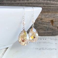 These earrings feature stunning Vintage glass crystal jewels in an antiques silver setting. They are an amazing light golden champagne color with loads of sparkle. They are dangled below Swarovski Crystal pearls wrapped onto sterling silver wire. Hung on sterling silver French hook earwires. These earrings are 42mm king or just over 1 and 5/8 inches including earwires. Jewels are 21mm tall and 13mm wide. * These earrings feature Vintage findings. They are very limited to stock on hand. Teardrop Faceted Earrings For Wedding, Faceted Teardrop Earrings For Weddings, Wedding Teardrop Faceted Earrings, Nickel-free Crystal Earrings For Anniversary, Nickel-free Sterling Silver Wedding Crystal Earrings, Elegant Faceted Crystal Earrings For Wedding, Sterling Silver Nickel-free Crystal Earrings For Wedding, Faceted Crystal Earrings For Wedding, Elegant Faceted Earrings For Wedding