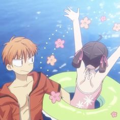 two people standing in an inflatable pool with flowers around them and one person holding his arm up