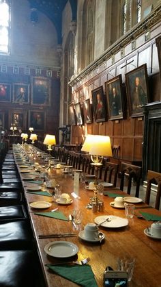 the long table is set with empty plates and place settings for people to sit at