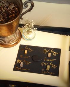 a table with some writing on it and a vase filled with baby's breath flowers