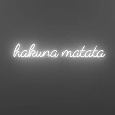 a neon sign with the words hakuna matata in white on a black background