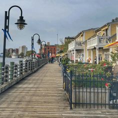 people walking on a wooden pier next to houses