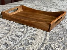 a wooden tray sitting on top of a bed