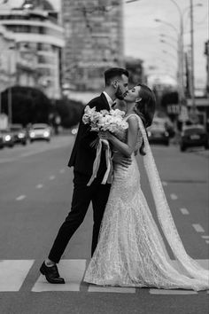 a bride and groom kissing on the crosswalk at their wedding in chicago, illinois