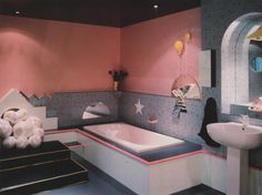 a bathroom with pink walls and black flooring is shown in this image, it has a large bathtub next to the sink