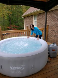 a woman standing next to an inflatable hot tub