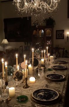 a dining room table is set with candles and plates