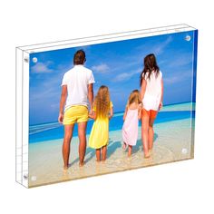 a family standing on the beach looking out at the ocean