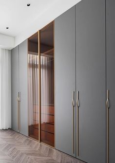 an empty room with grey cabinets and wooden floors