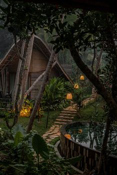 an outdoor area with steps leading up to a house in the woods, surrounded by greenery and trees