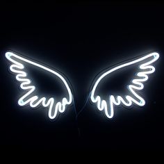 an angel wings neon sign in the dark