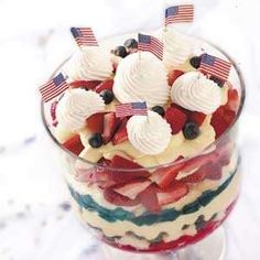 a trifle with strawberries, blueberries, and american flags in it on a table