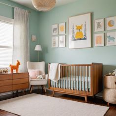 a baby's room with blue walls and pictures on the wall, including a crib