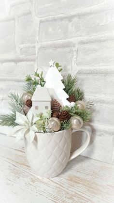 a white mug filled with christmas decorations on top of a wooden table