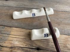 two ceramic toothbrush holders with the letter b on them