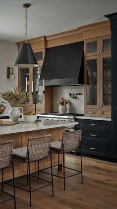 a kitchen with wooden floors and black cabinets