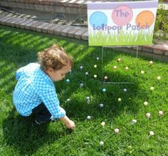 a little boy playing in the grass with easter eggs