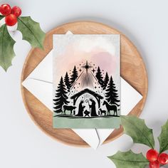 a christmas card with the nativity scene on it and holly wreaths around it