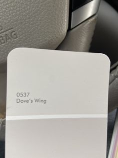 a close up of a white business card on a car seat with the name dove's wing