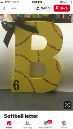 the letter b is decorated with baseball stitches and a black bow on it's tail