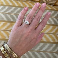 a woman's hand with two gold bracelets and a diamond ring on it