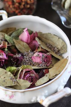 a white bowl filled with lots of flowers on top of a table