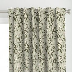 a white curtain with green leaves on it