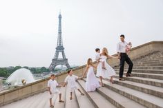 a family walking up some steps in front of the eiffel tower