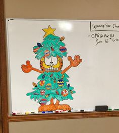 a whiteboard with a drawing of a christmas tree on it