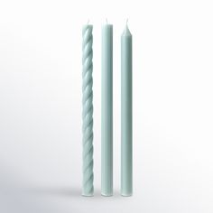 two white candles sitting next to each other