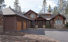 a large house with two garages and lots of trees in front of the house