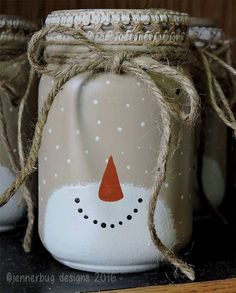 three mason jars with snowmen painted on them