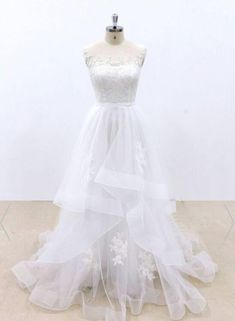 a white wedding dress on a mannequin with sheer tulle and appliques