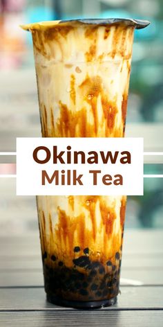 a drink in a glass with the words okinawa milk tea written on it