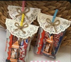 two small bags with candy in them sitting next to a basket filled with toothbrushes