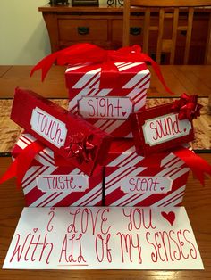 three wrapped presents are stacked on top of each other with red ribbon and handwritten words