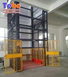 the inside of a large room with several cages on each side and one door open