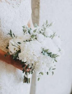 a bridal holding a bouquet of white flowers