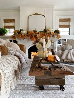 a living room filled with furniture and a fire place covered in fall leaves on top of a coffee table