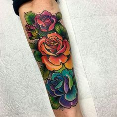 a colorful rose tattoo on the leg