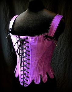 a pink corset with black laces on it