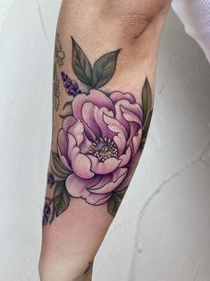 a woman's arm with a flower tattoo on the left side of her leg