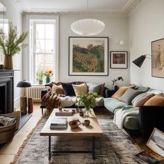 a living room filled with lots of furniture and paintings on the wall above it's fireplace