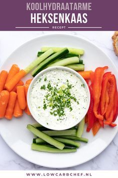 a white plate topped with carrots and celery next to a bowl of dip