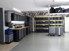 a garage filled with lots of black and gray cabinets next to a workbench