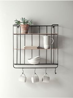 a shelf with cups and saucers hanging from it